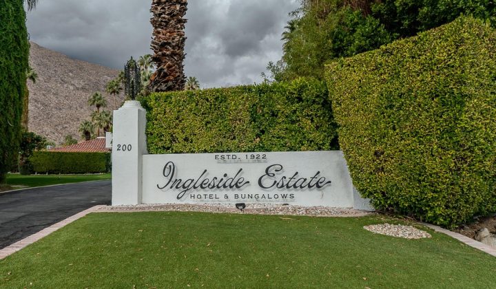 Sign reading "Ingleside Estate Hotel & Bungalows, Estd. 1922" surrounded by trimmed hedges and palm trees.