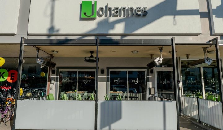 Facade of a restaurant named Johannes with outdoor seating area and glass panels.