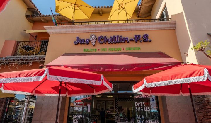 Ice cream shop with red umbrellas and yellow parasols. Sign reads "Jus Chillin - P.S." offering gelato, ice cream, and shakes.