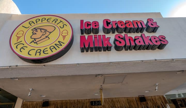 Sign for Lappert's Ice Cream and Milk Shakes on a building exterior, featuring a circular logo with a caricature of a man.