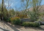 Entrance sign for Moorten Botanical Garden surrounded by various desert plants and cacti.