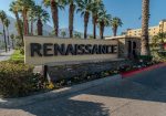 Sign reads "Renaissance" surrounded by flowers and palm trees, with a multi-story building in the background.