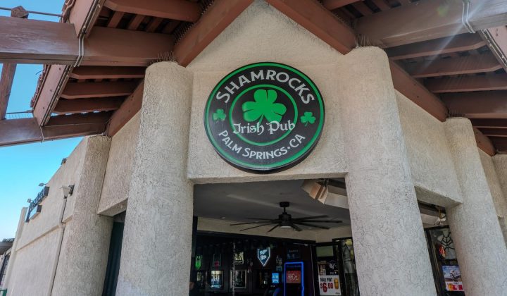 Entrance to Shamrocks Irish Pub in Palm Springs, CA, featuring a sign with a shamrock logo above the door.