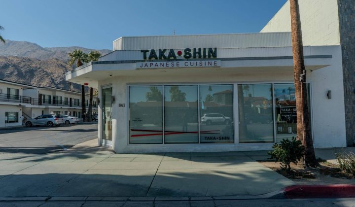 Street view of Taka Shin Japanese Cuisine restaurant on a sunny day with mountains in the background.